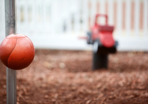 tetherball pole with playground in the background