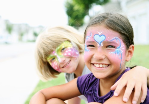 Girls smile at the camera with painted faces during a visit to Tanners Orchard, which offers Family Fun to Quad Cities IL families