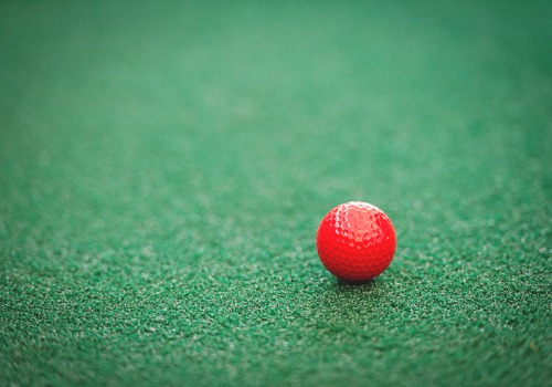 red golf ball on green astroturf for mini golf
