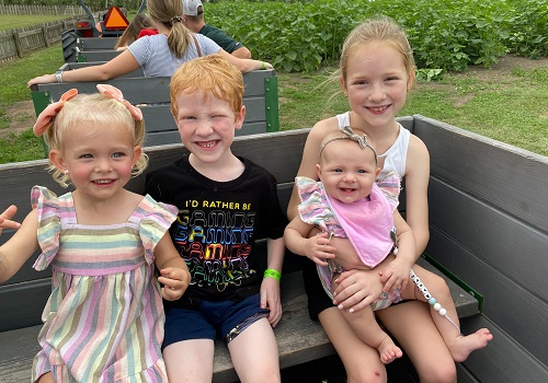 Four children ride in the back of a tractor to pick apples at Tanners Orchard. When you're looking for Family fun in Freeport IL, make the drive to Tanners Orchard.