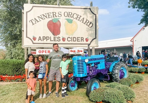 A happy family posing for a picture at Tanners Orchard, having fun after plenty of Family Activities near Ottawa IL