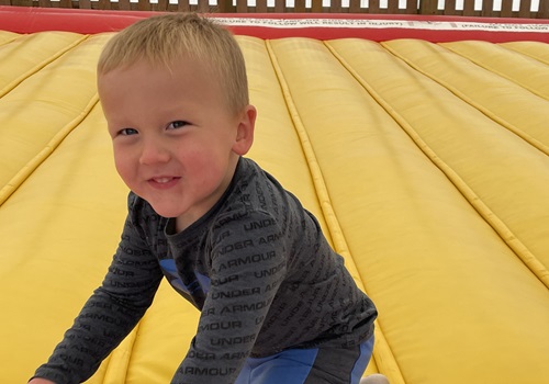 A child smiles at a camera while playing at Tanners Orchard, an Event Venue by East Peoria IL