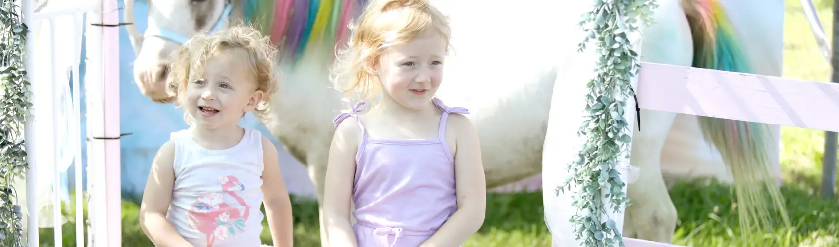 Two girls getting their picture taken with a Unicorn at Tanners Orchard